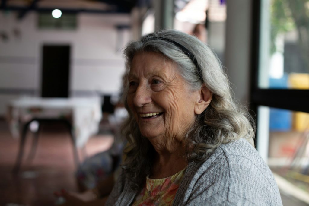 smiling woman in gray cardigan