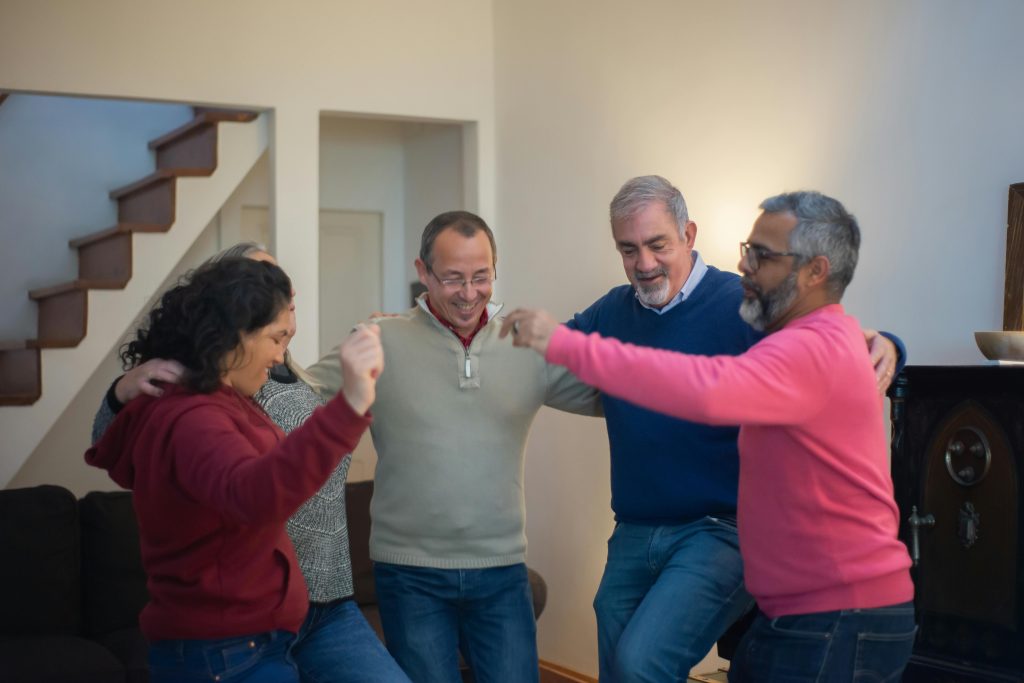 A group of friends enjoying a lively indoor dance session, showcasing warmth and togetherness.